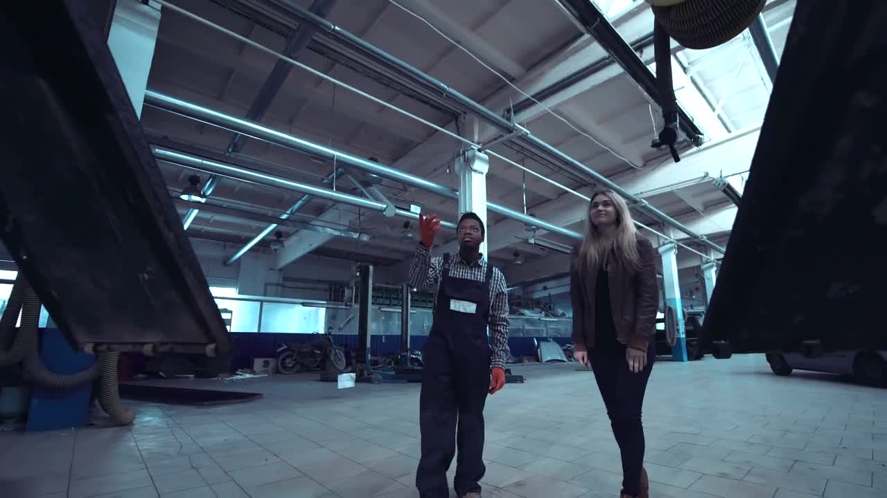 Stock Video Mechanic Shows The Bottom Of A Car To A Woma Animated Wallpaper