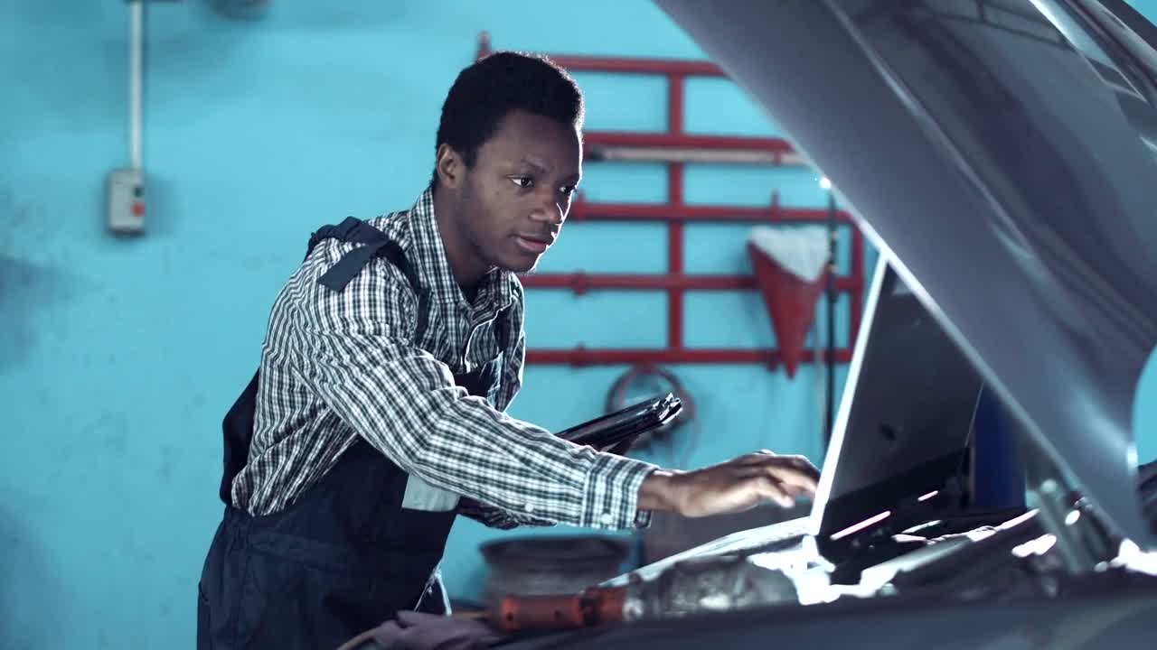 Stock Video Mechanic Checking A Car Motor With Compute Animated Wallpaper
