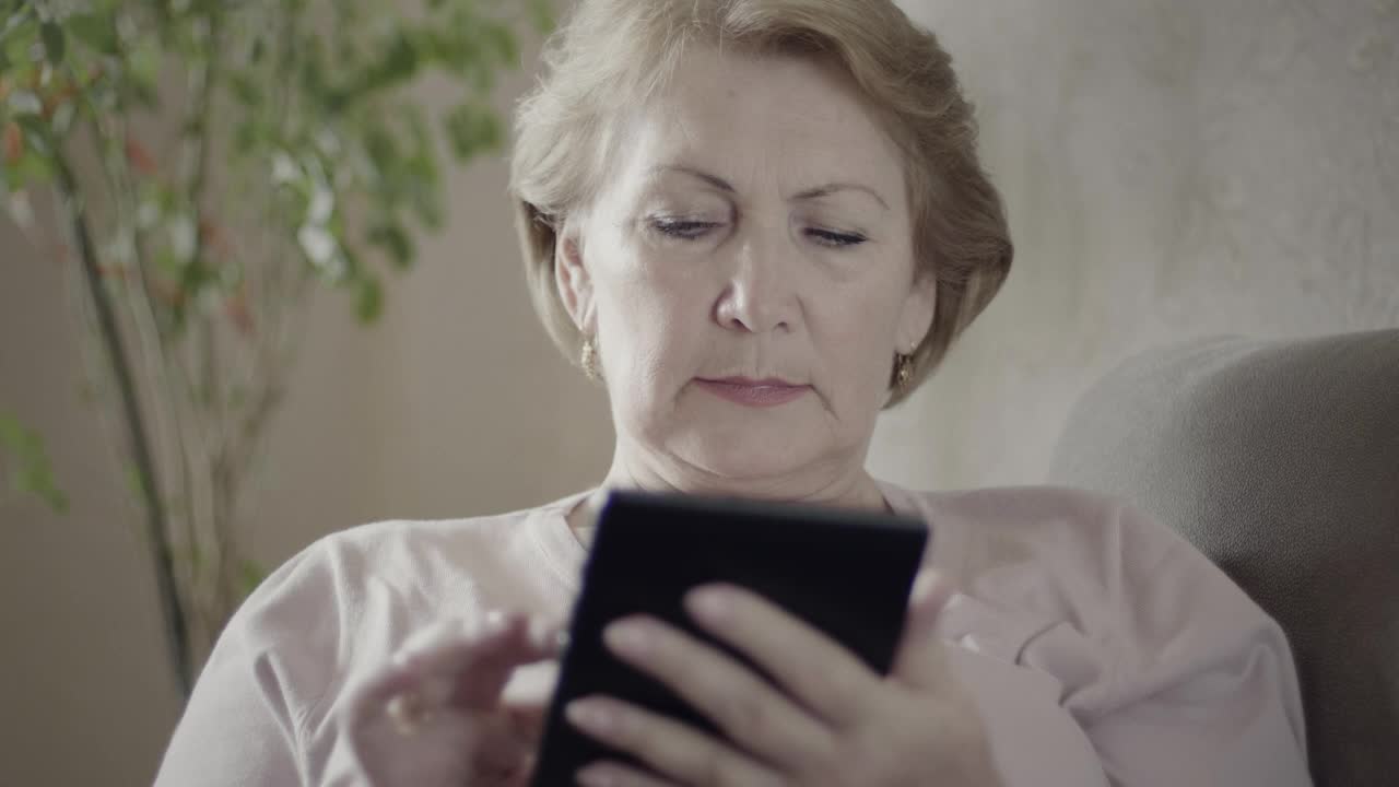 Stock Video Mature Woman Using An Electronic Reading Devic Animated Wallpaper