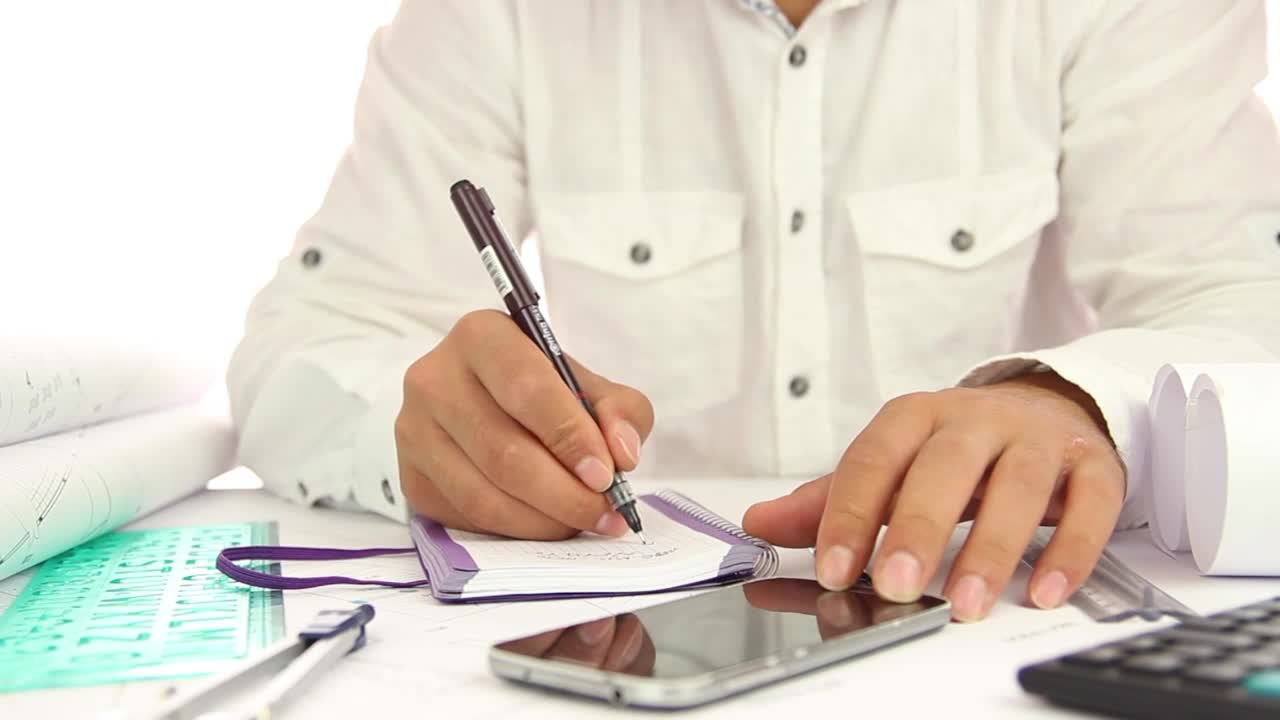 Stock Video Man Writing In A Notebook At His Offic Animated Wallpaper