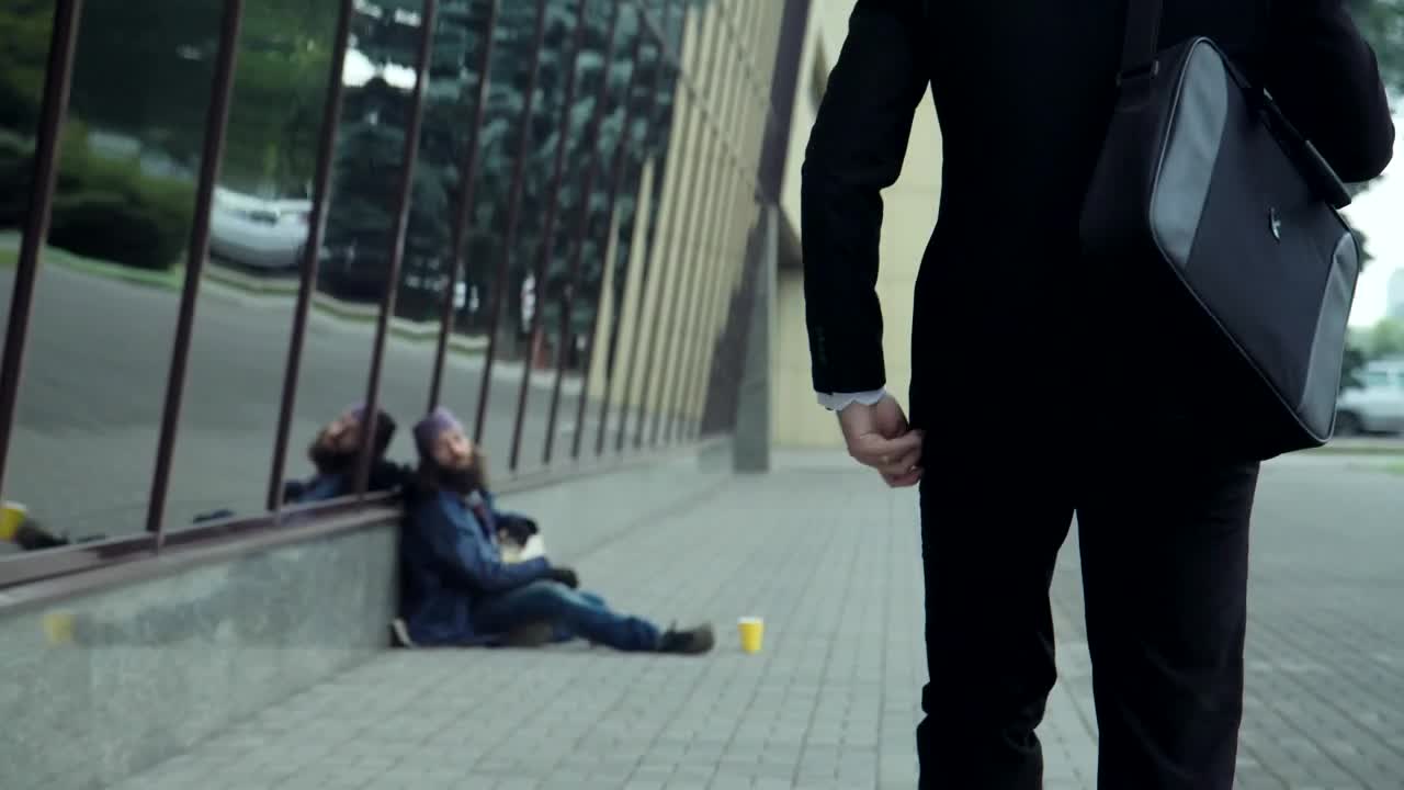 Stock Video Man Working On The Street Gives Money To Homeles Animated Wallpaper