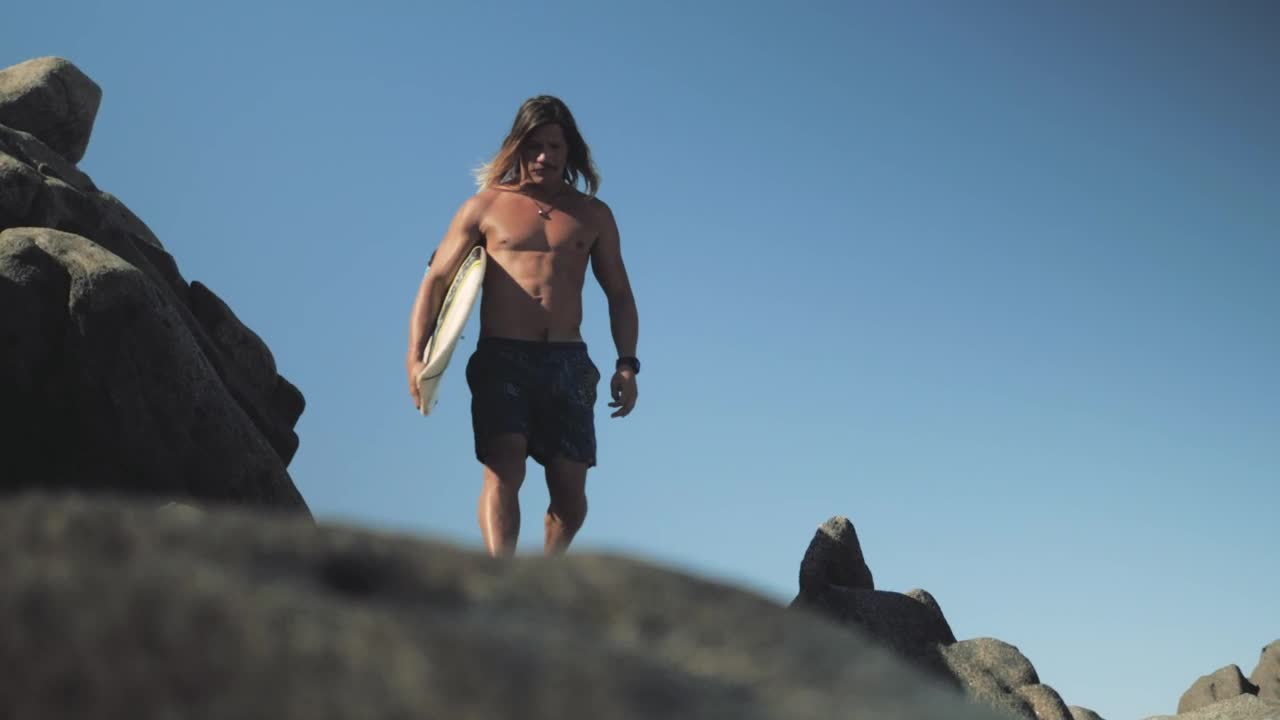 Stock Video Man With Surfboard Walks On Rocks At The Se Animated Wallpaper