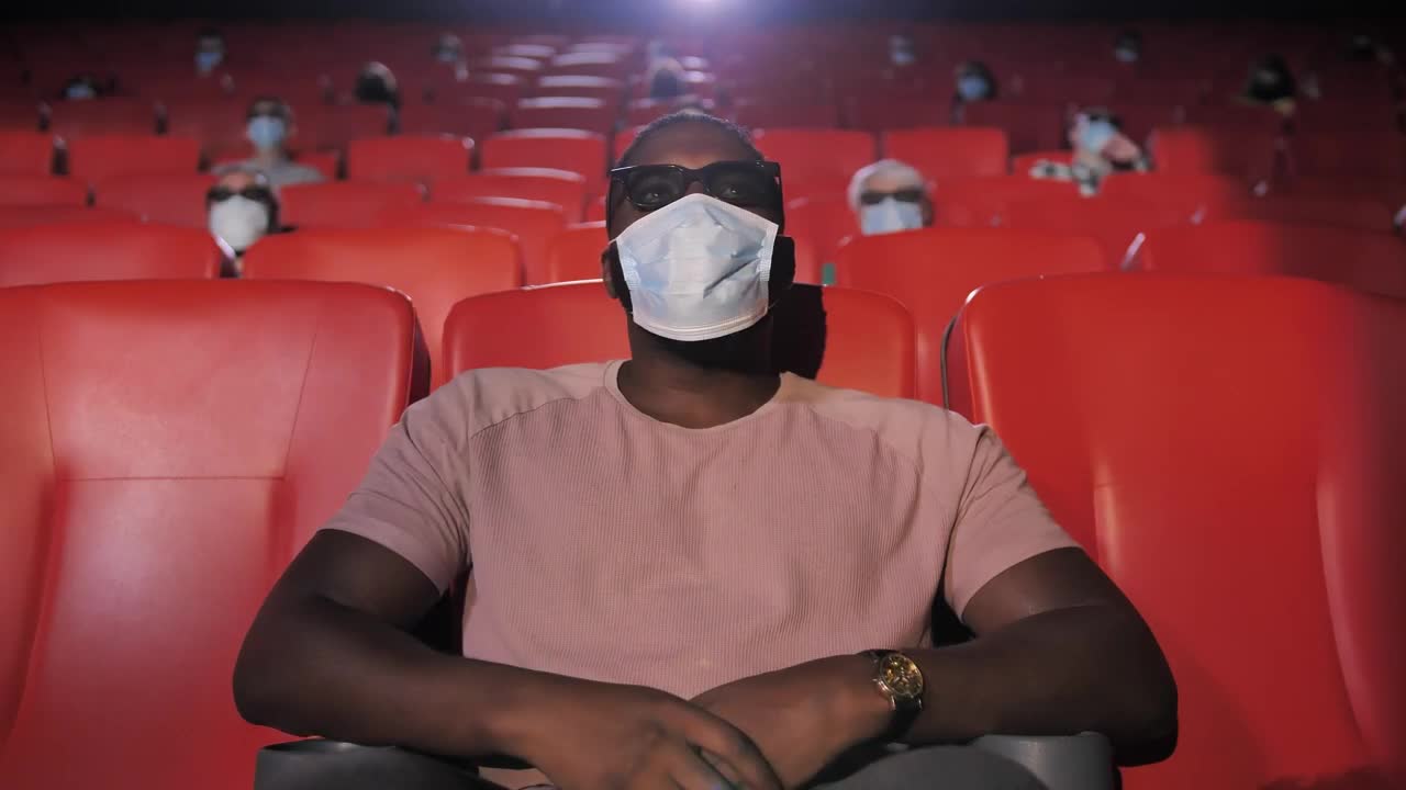 Stock Video Man With Mask Sitting In A Movie Theate Animated Wallpaper