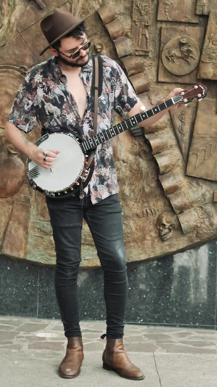 Stock Video Man With Dark Glasses And Hat While Tuning His Banj Animated Wallpaper