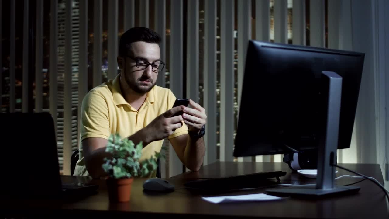 Stock Video Man Using His Phone At The Office At Nigh Animated Wallpaper