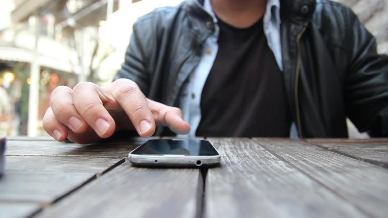 Stock Video Man Using A Smartphone On A Wooden Tabl Animated Wallpaper