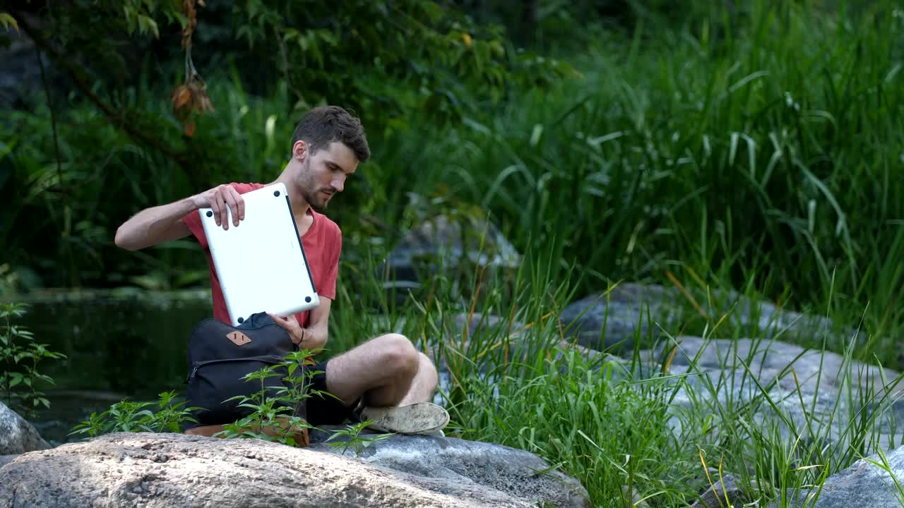 Stock Video Man Using A Laptop By A Strea Animated Wallpaper