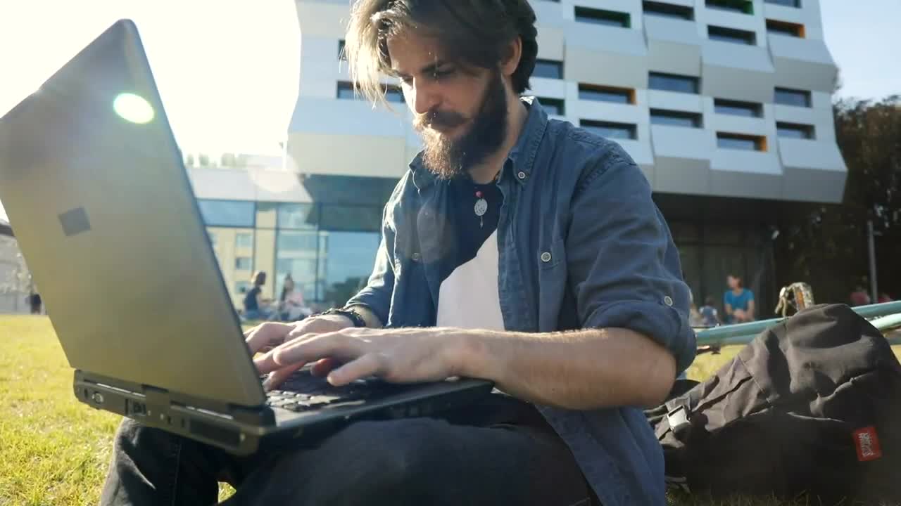 Stock Video Man Typing On Laptop Outside Smiles In Triump Animated Wallpaper