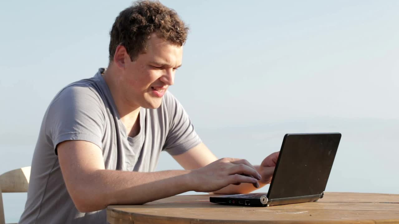 Stock Video Man Typing On A Small Personal Compute Animated Wallpaper