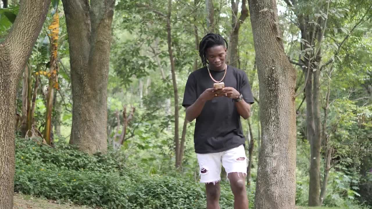 Stock Video Man Texting On Cell Phone While Walking In Par Animated Wallpaper