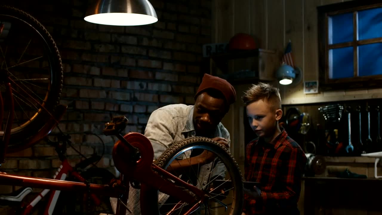 Stock Video Man Teaching A Boy Bicycle Maintenanc Animated Wallpaper