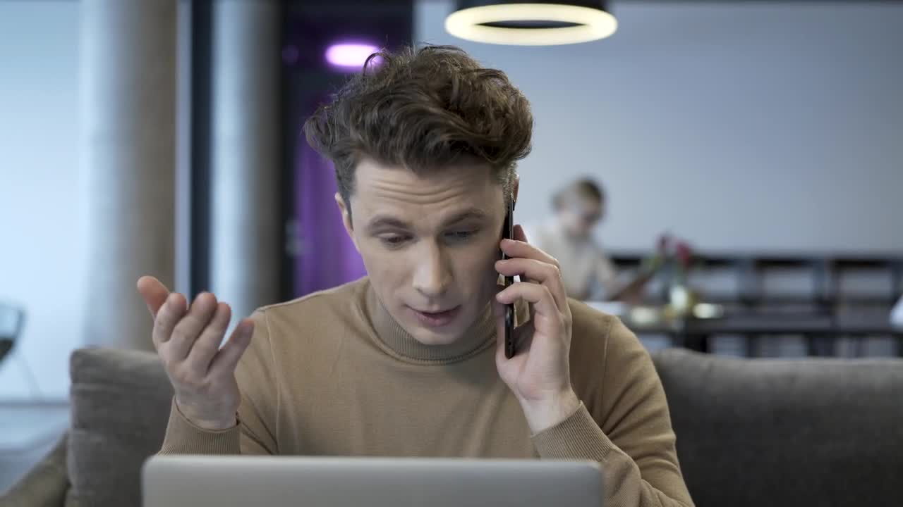 Stock Video Man Talking On The Phone While Working On The Compute Animated Wallpaper