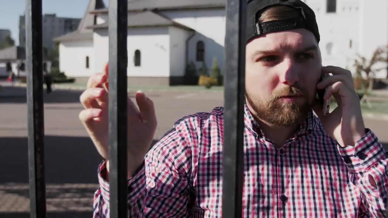 Stock Video Man Talking On The Phone By A Metal Gat Animated Wallpaper