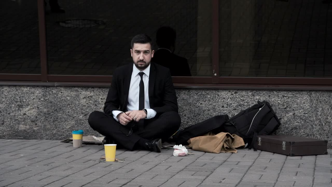 Stock Video Man Taking Off His Tie Sitting On The Stree Animated Wallpaper