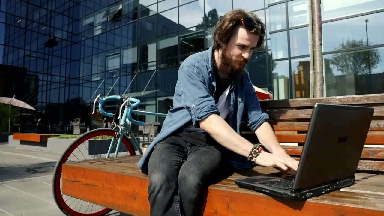 Stock Video Man Surfs Internet On Laptop From Street Benc Animated Wallpaper