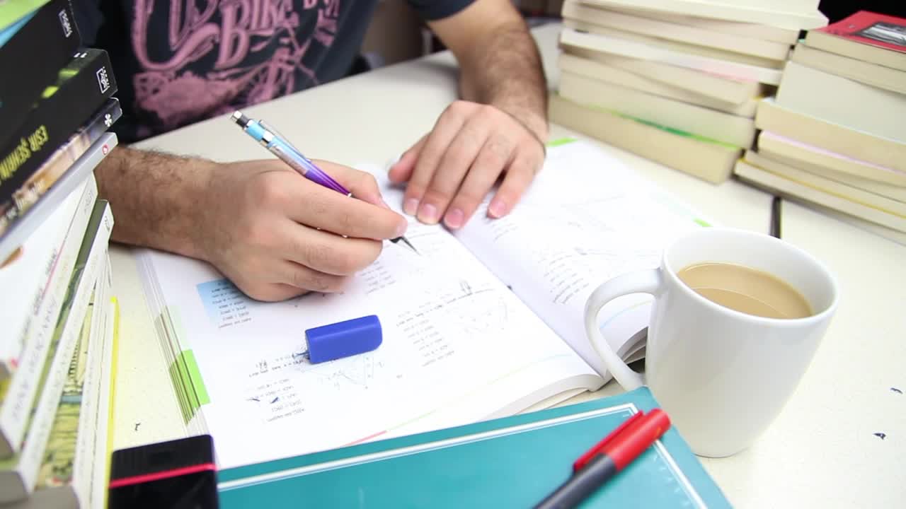 Stock Video Man Studying With A Cup Of Coffee And Many Book Animated Wallpaper