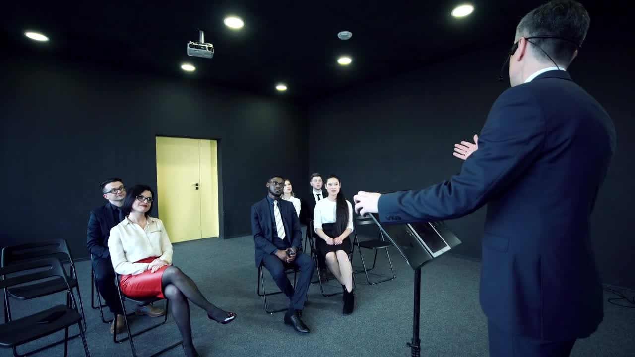 Stock Video Man Speaking In Front Of A Small Audienc Animated Wallpaper