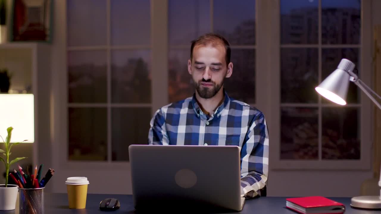 Stock Video Man Smiles While Thinking And Working From Hom Animated Wallpaper