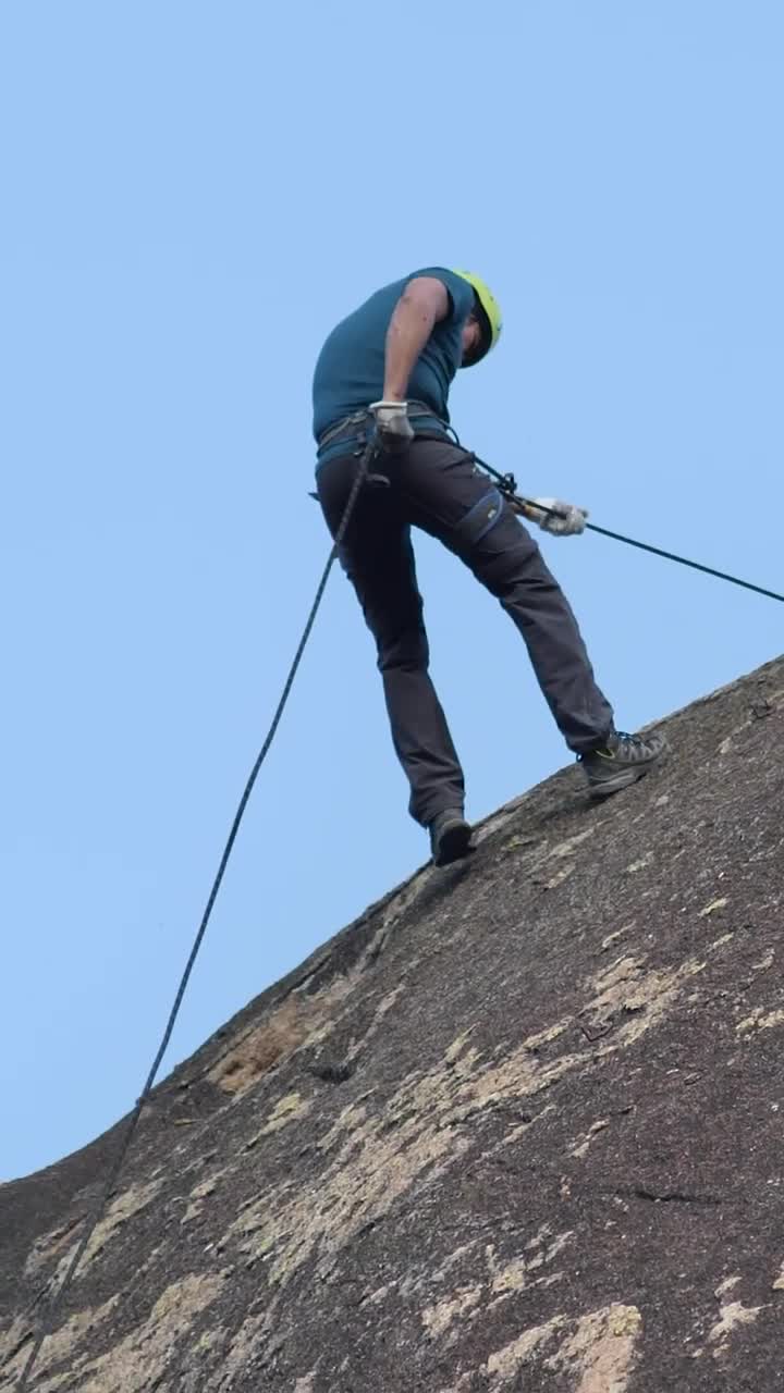 Stock Video Man Slowly Descending Rocky Mountai Animated Wallpaper