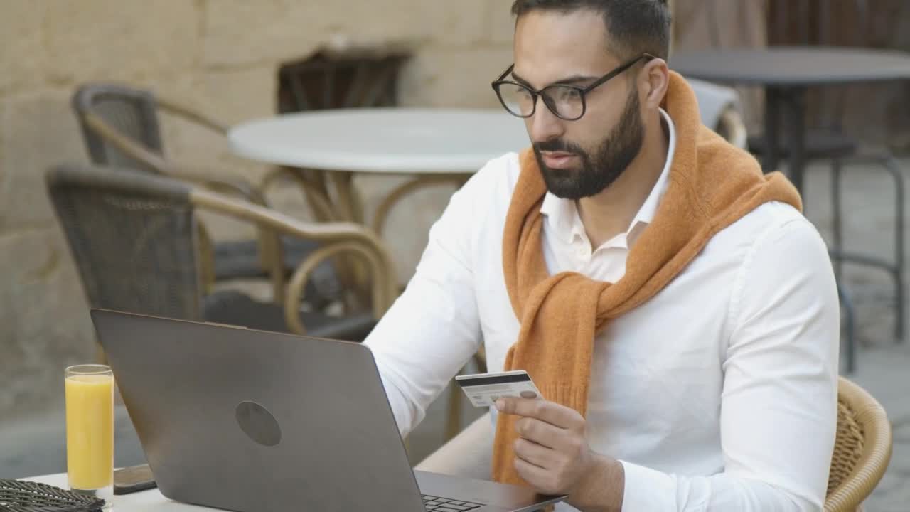 Stock Video Man Shops Online In Cafe And Pays With Credit Car Animated Wallpaper
