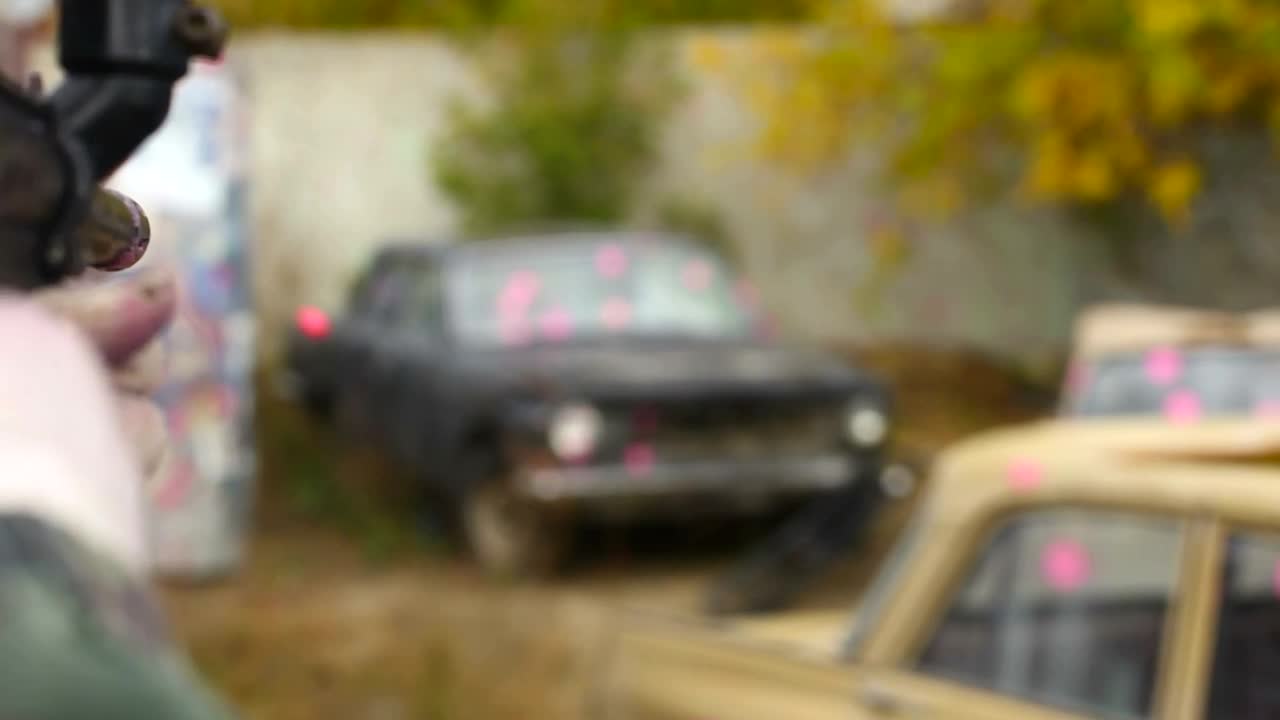 Stock Video Man Shooting Paintballs To An Old Ca Animated Wallpaper