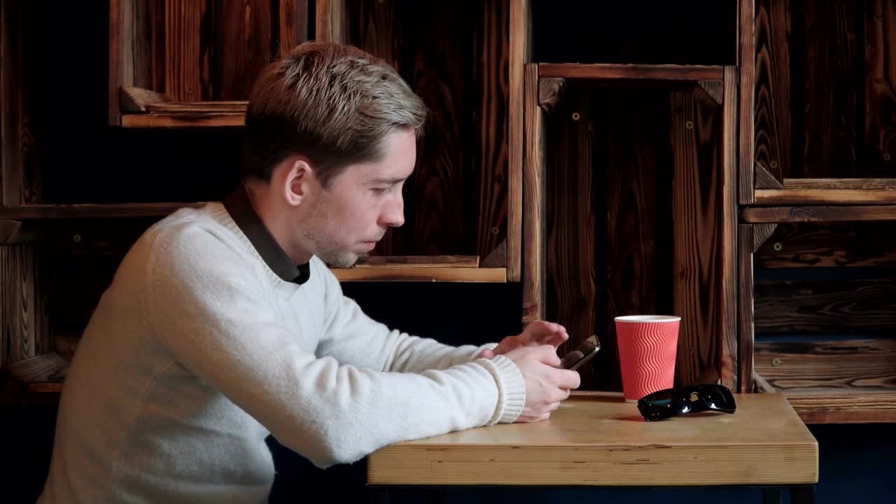 Stock Video Man Scrolling Through His Phone In A Caf Animated Wallpaper