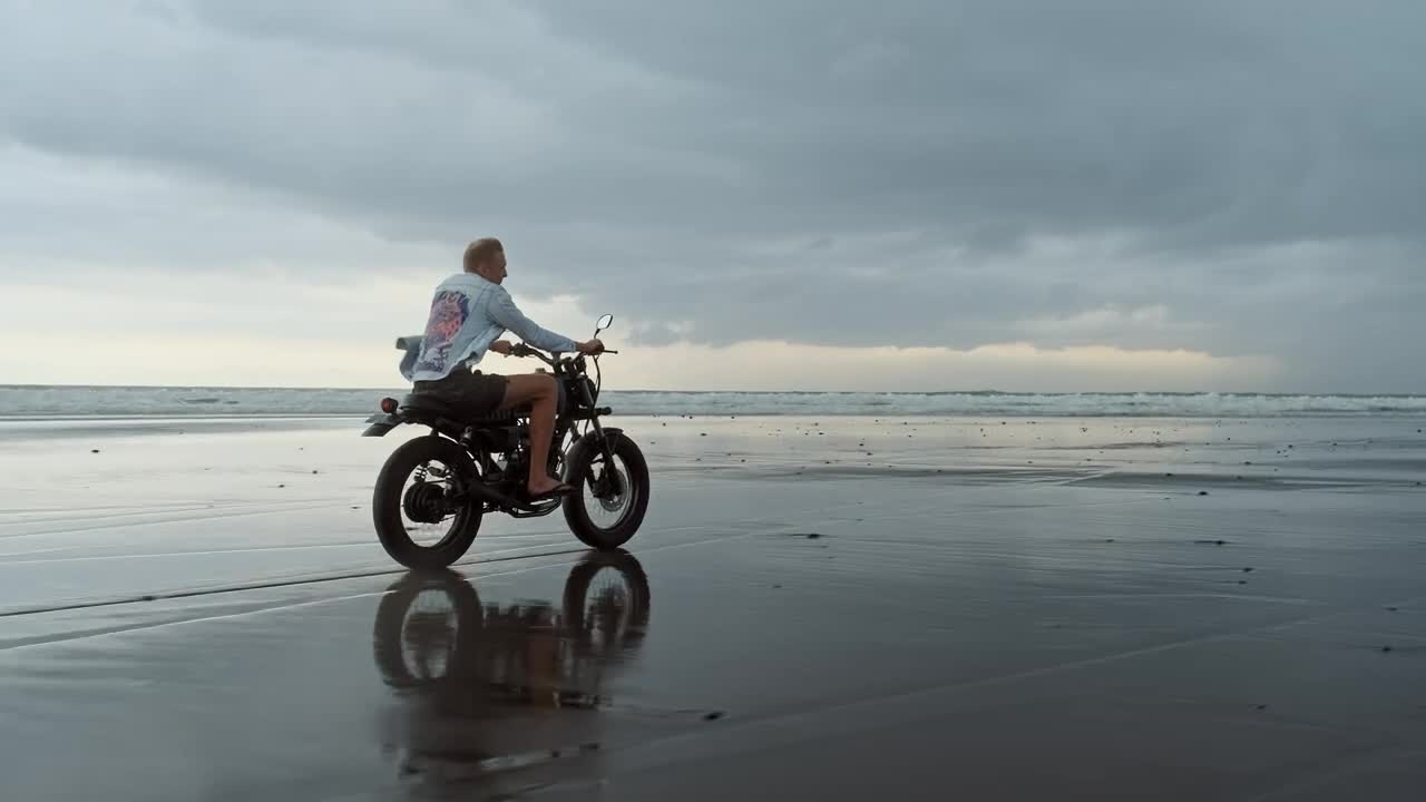 Stock Video Man Riding Motorcycle On The Beach On A Cloudy Da Animated Wallpaper
