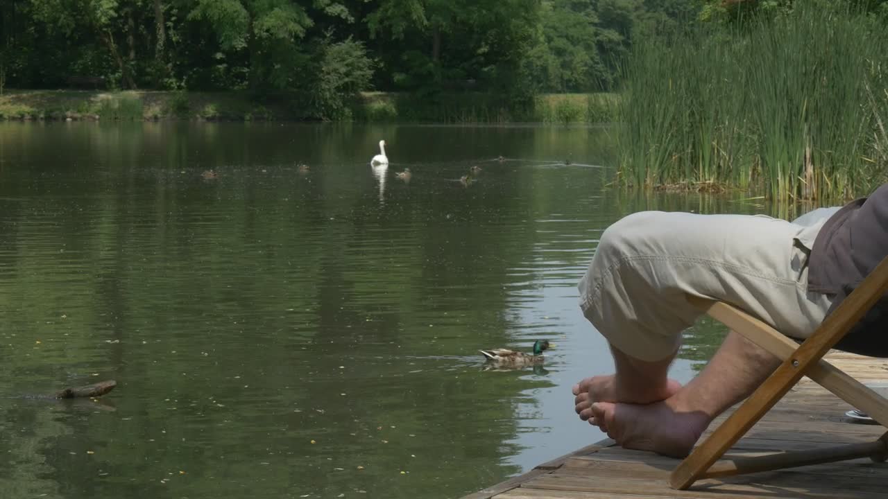 Stock Video Man Relaxing On A Chair By The Lak Animated Wallpaper