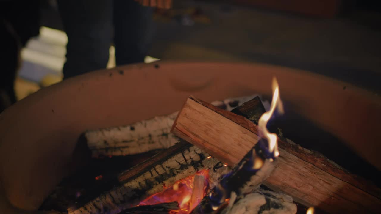 Stock Video Man Putting Firewood For A Campfir Animated Wallpaper