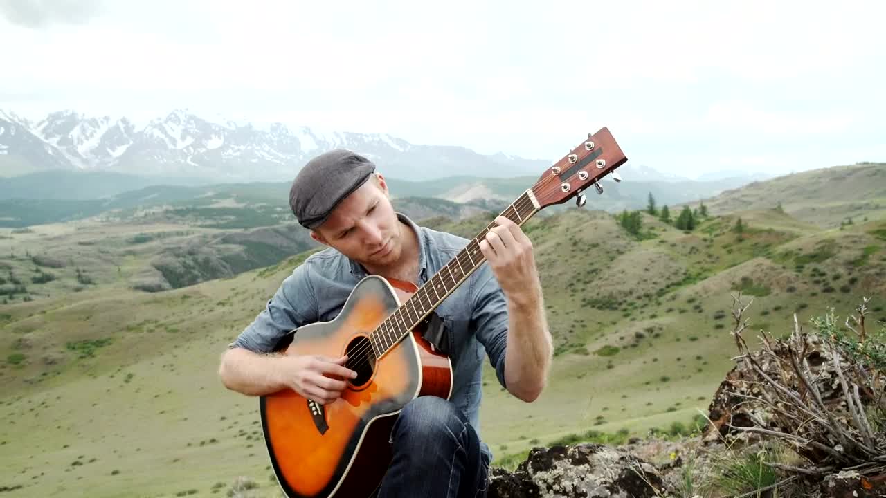 Stock Video Man Plays Acoustic Guitar On Ridge Above Mountain Landscap Animated Wallpaper