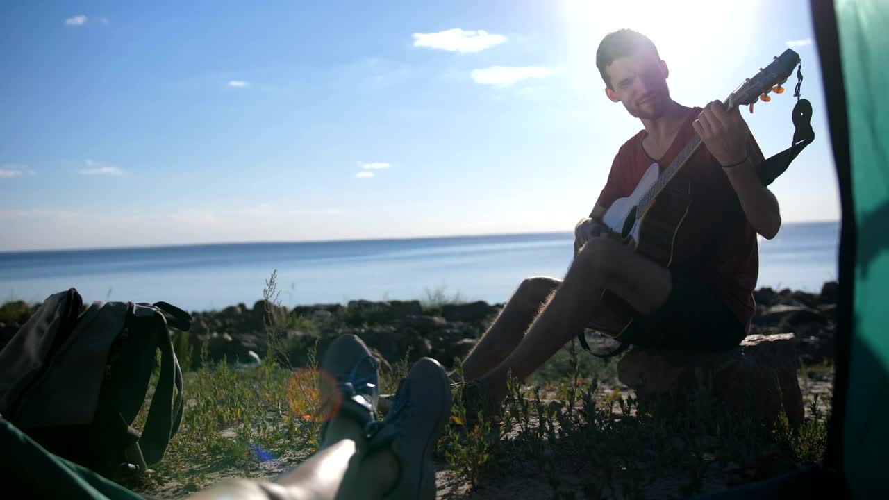 Stock Video Man Playing A Guitar While Campin Animated Wallpaper