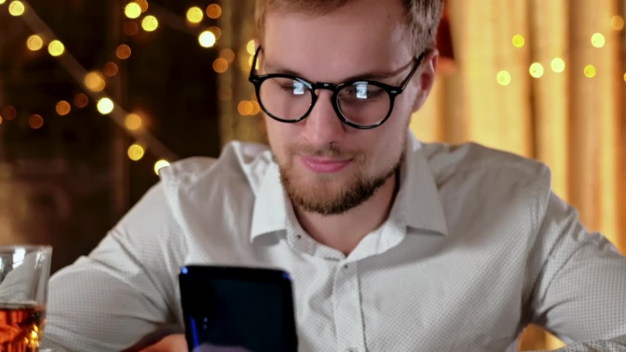 Stock Video Man On Mobile Phone With Whisky And Bokeh Light Animated Wallpaper