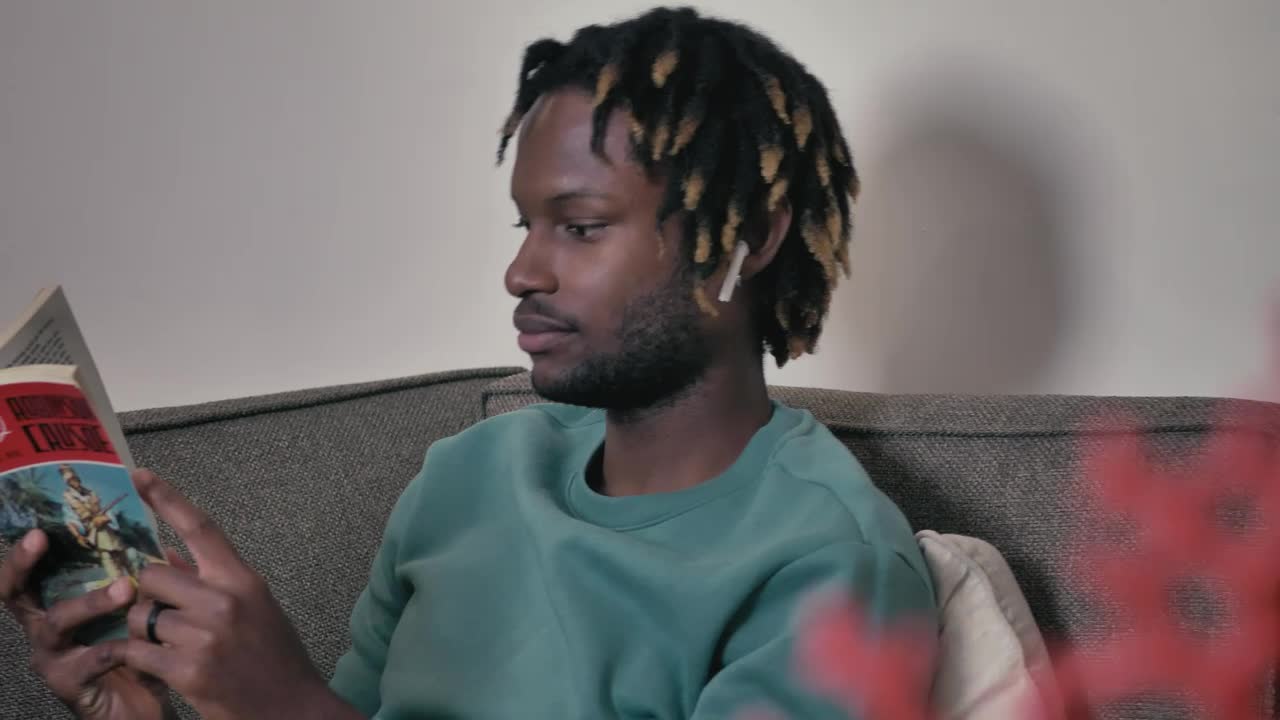 Stock Video Man On A Sofa Listening To Music And Reading Animated Wallpaper