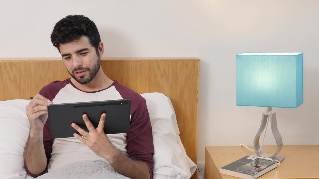 Stock Video Man Lying On Bed Drawing On A Table Animated Wallpaper