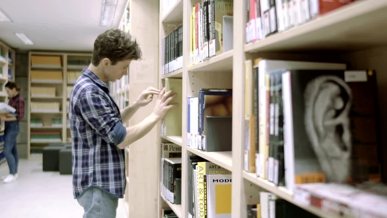 Stock Video Man Looking For A Book In The Librar Animated Wallpaper
