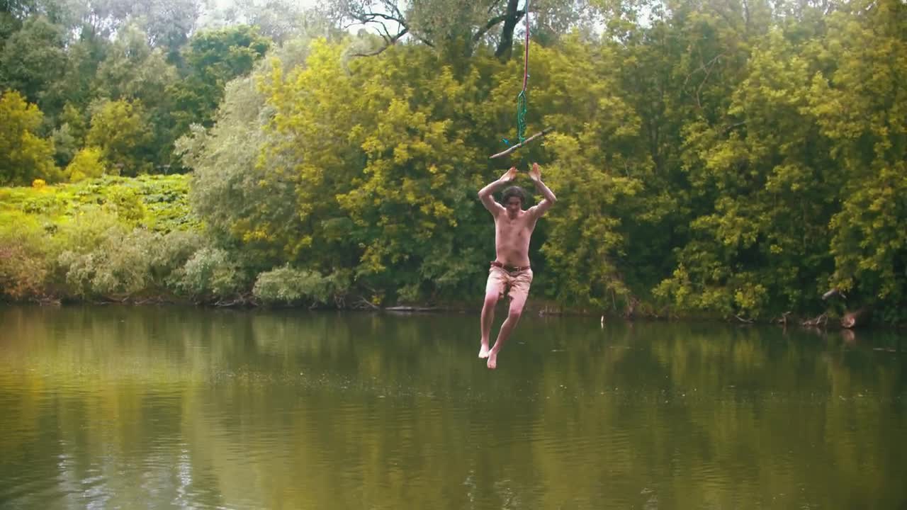 Stock Video Man Jumps Into A Lake By Swinging With A Rop Animated Wallpaper
