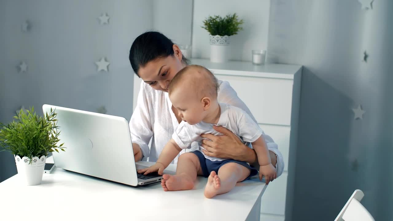 Stock Video Mother Working On Her Laptop With Her Son Live Wallpaper