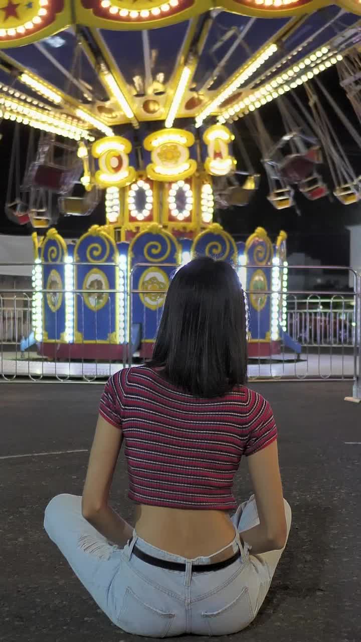 Stock Video Motionless Woman Sitting On The Floor Watching Mechanical Flying Chairs Live Wallpaper