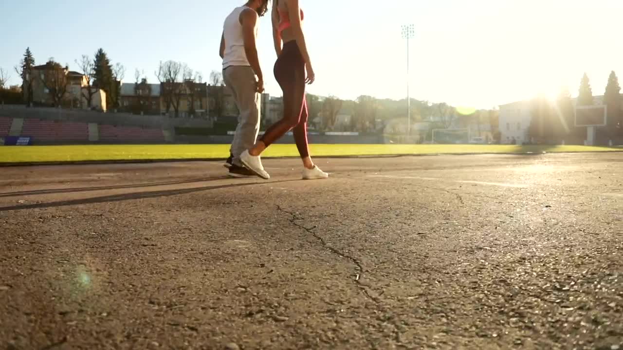Stock Video Motivated Couple Lunge At Start Of Race On Outdoor Track Live Wallpaper