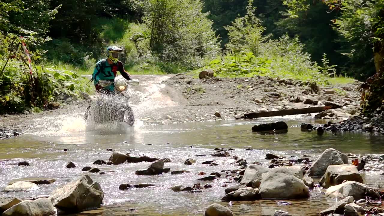 Stock Video Motocross Rider Crosses A River In The Mountain Live Wallpaper