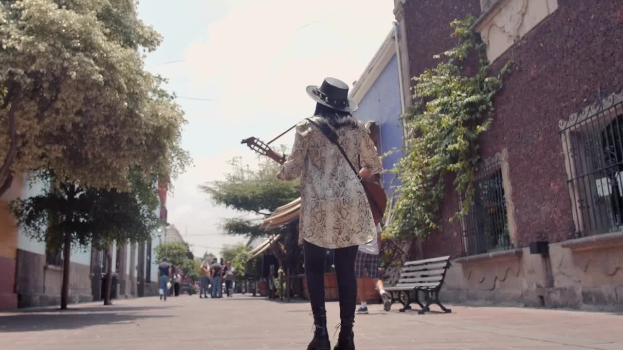 Stock Video Mujer Caminando Por Una Calle Colonial Mientras Toca Su Guitarra Live Wallpaper