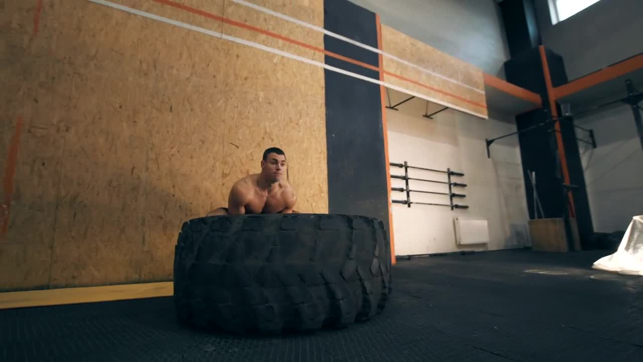 Stock Video Muscular Man Doing Crossfit With A Big Tire Live Wallpaper