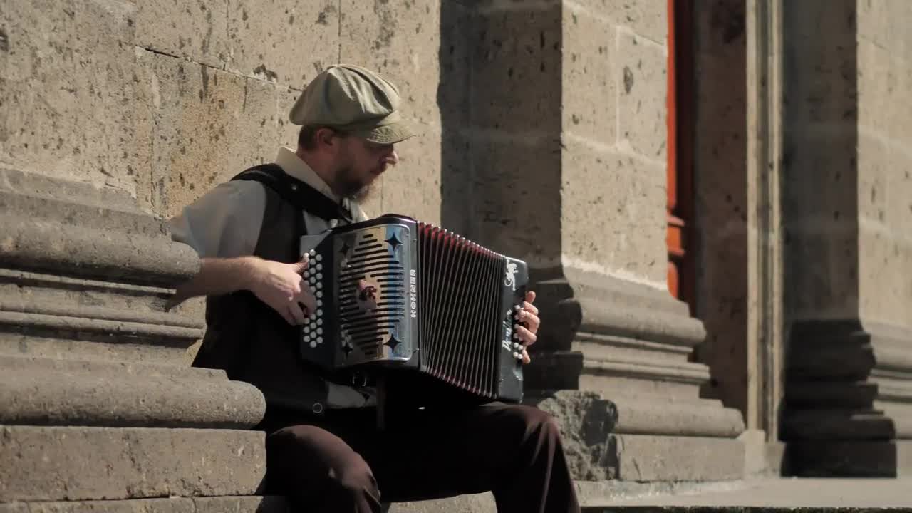 Stock Video Musician Playing Accordion In Front Of A Concrete Building Live Wallpaper