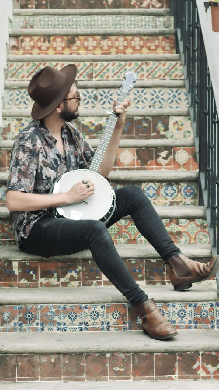 Stock Video Musician Sitting On An Old Ladder Playing His Banjo Live Wallpaper