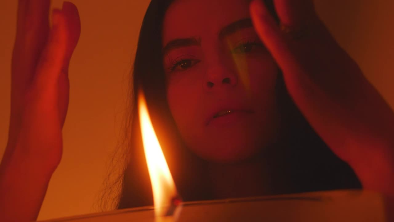 Stock Video Mysterious Woman Appreciating The Flame Of A Candle Live Wallpaper