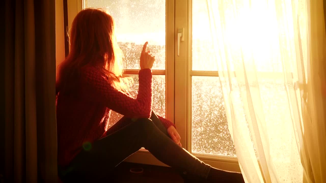 Stock Video Nostalgic Woman Watching The Sunset By The Window Live Wallpaper