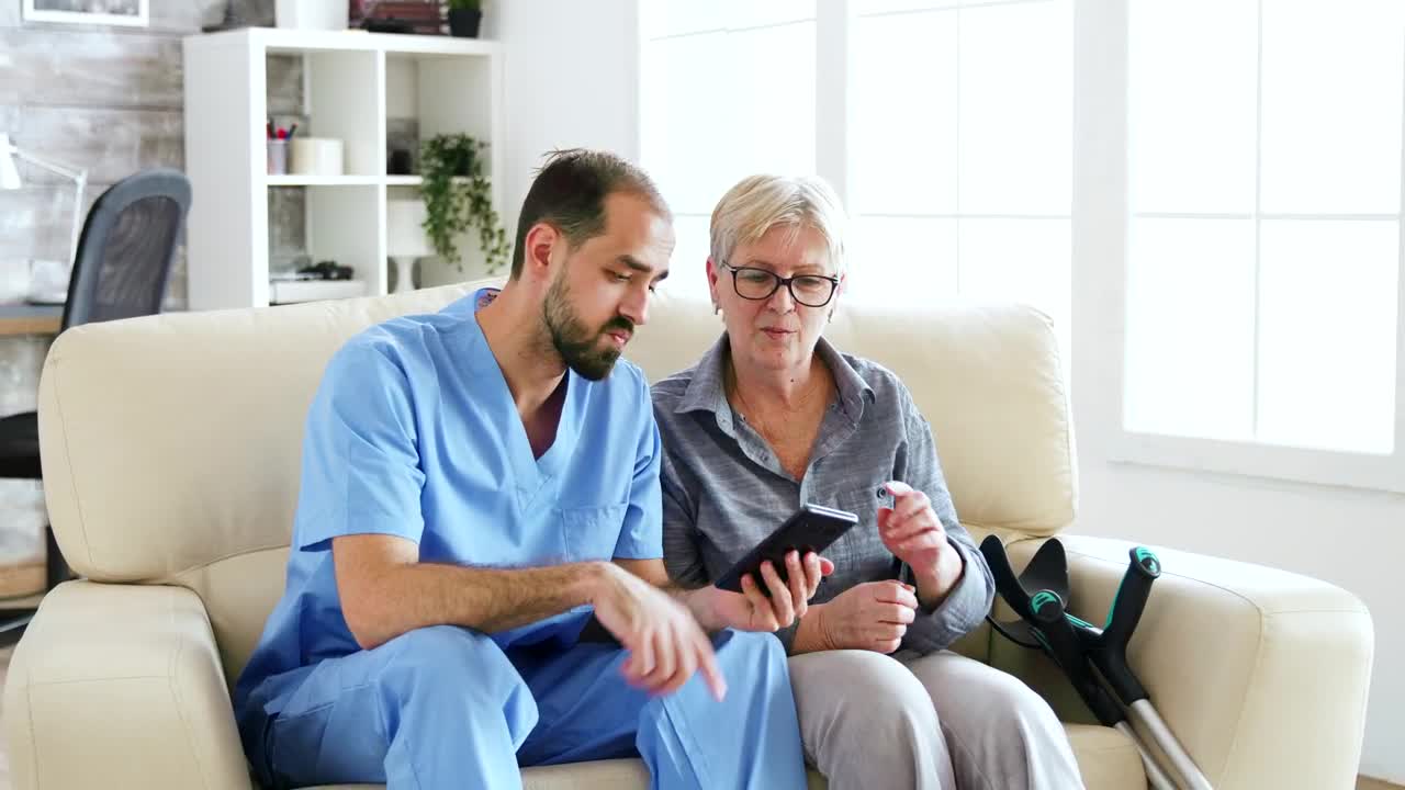 Stock Video Nurse Helps Woman Use App On Mobile Phone Live Wallpaper