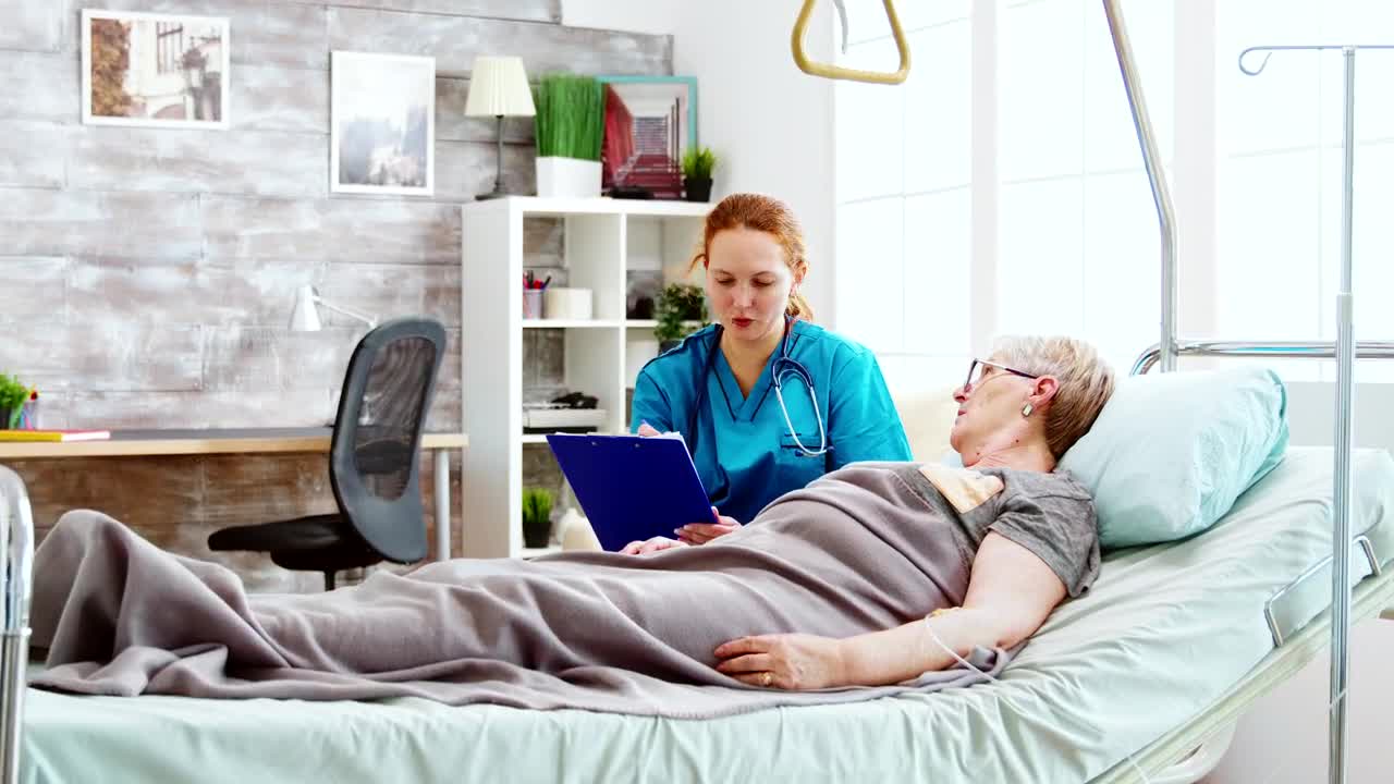 Stock Video Nurse Talks With Woman Laying In Hospital Bed Live Wallpaper