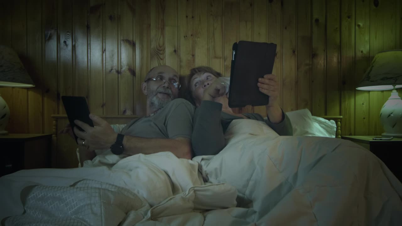 Stock Video Old Couple With Tablets In The Bedroom Live Wallpaper