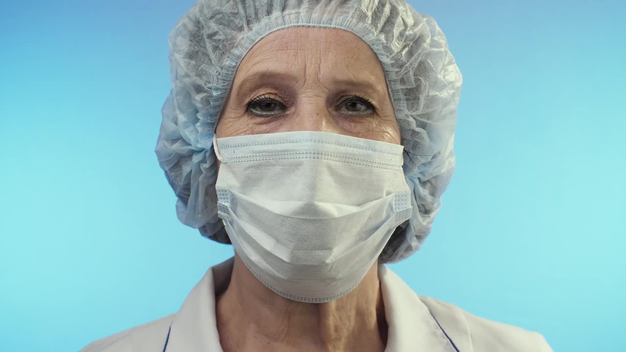 Stock Video Old Female Doctor Wearing Face Shield From Surgery Live Wallpaper